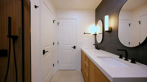 Modern bathroom interior with double sink vanity, round mirrors, wooden Stock Footage 331024719