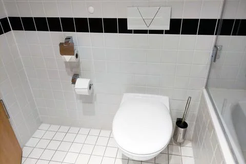 Modern bathroom interior featuring a clean, white tiled design. the space inc Stock Photos