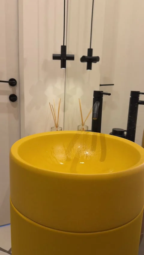 Modern bathroom interior with a yellow vessel sink, black faucet, stylish Stock Footage 345172579