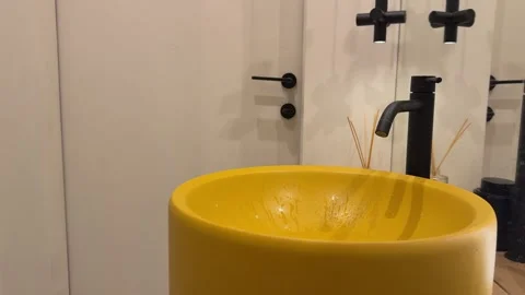 Modern bathroom interior with a yellow vessel sink, black faucet, stylish Stock Footage 345173280