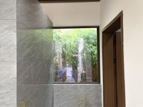 Modern Bathroom with Large Window Overlooking Lush Green Bamboo Garden Stock Photos