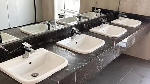 Modern bathroom with multiple sinks on marble countertop Stock Photos