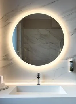 A modern bathroom with a round illuminated mirror Stock Photos