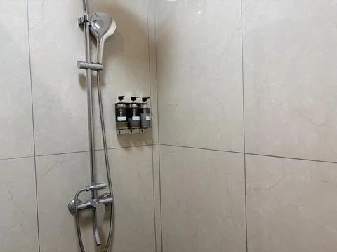 Modern Bathroom Shower with Wall-Mounted Dispensers Stock-Fotos