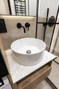 Modern bathroom sink with black wall faucet Stock Photos