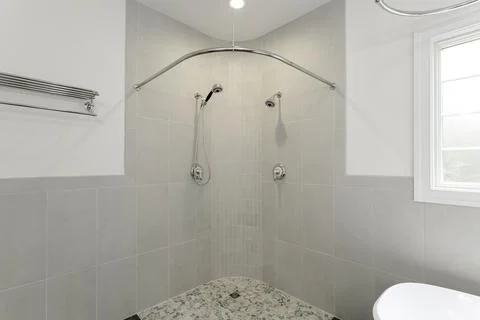 Modern Bathroom With Spacious Double Shower, Grey Tiles, And Natural Light. Stock Photos