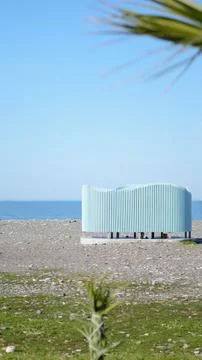 Modern beach structure with wavy design near the ocean on a sunny day Stock Photos