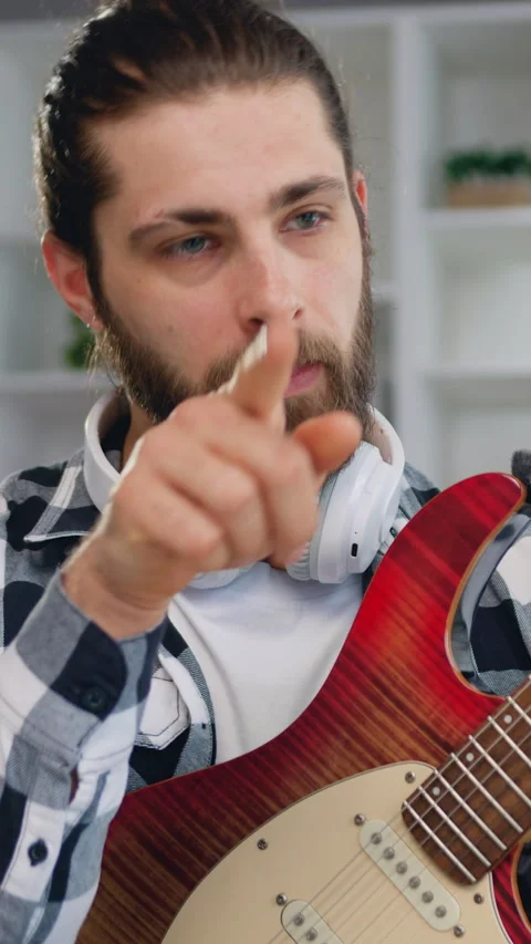 Modern bearded awesome man using laptop has online guitar lessons, courses, arti Stock Footage 325987924