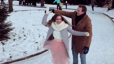 Modern beautiful couple having fun skating on the outdoor rink in winter Stock Footage 72322205