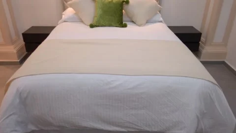Modern Bed With A Neutral Diamond-Tufted Headboard And Throw Pillows. - tilt up Stock Footage 337143109