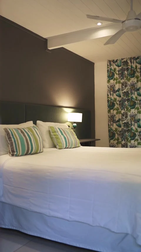 Modern bedroom interior with a comfortable bed and decorative curtain patterns Stock Footage 299705515