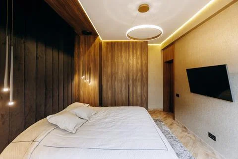 A Modern Bedroom Interior Featuring Stylish Lighting Accentuated by Warm Tones Stock Photos