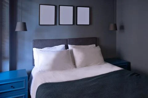 Modern bedroom in luxury apartment in dark blue colors with picture foto frames Stock Photos