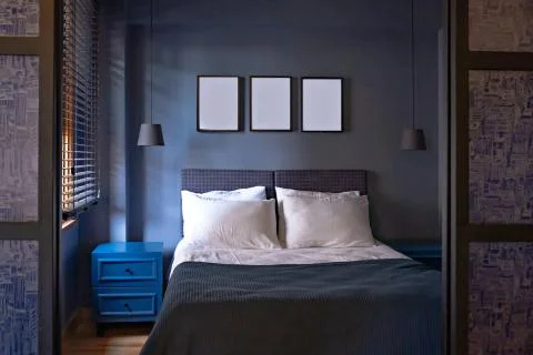 Modern bedroom in luxury apartment in dark blue colors with picture foto frames Stock Photos