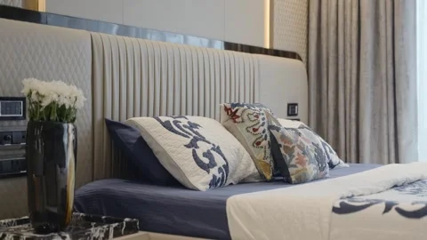 Modern bedroom with patterned pillows and blue bedding. Reveal shot of marble Stock Footage 328482677