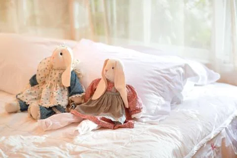 Modern bedroom with rabbit dolls on bed.. Stock Photos