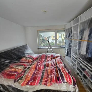 A modern bedroom setup featuring plastic protection to ensure the space remains Stock Photos
