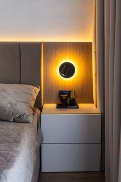 Modern bedside table with glowing wall lamp and pineapple decor Fotos de archivo