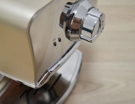 Modern beige coffee machine stands on a wooden background. Stock Photos
