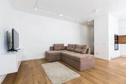 Modern beige l-shaped sofa in bright living room Stock-Fotos