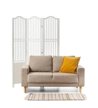 Modern beige two-seater sofa with yellow cushion and white room divider, mini Stock Photos
