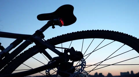 Modern Bicycle on the Evening Sunset with Enabled Red Signal Lamp. 4K Stock Footage 47882533