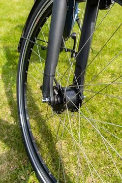 Modern bicycle front wheel featuring silver metal spokes and a black hub co.. Stock Photos