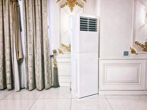 Modern big vertical white floor air conditioner in luxury interior Stock Photos