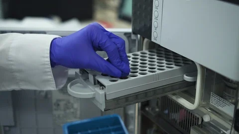 Modern biochemical analyzer filled with test tubes. spbd Genetics worker putting Stock Footage 128989369