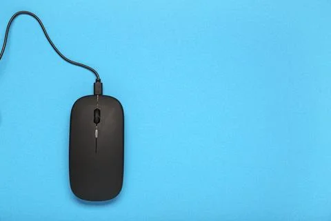 Modern black computer mouse on blue background Stock Photos