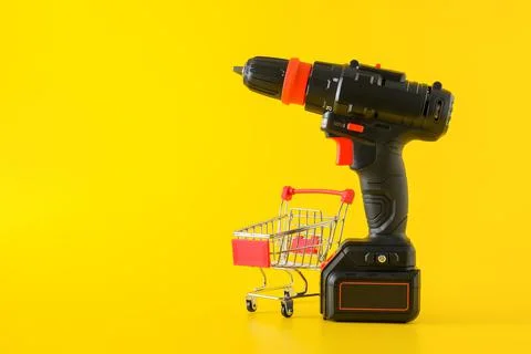 Modern black cordless screwdriver with empty shopping cart Stock Photos