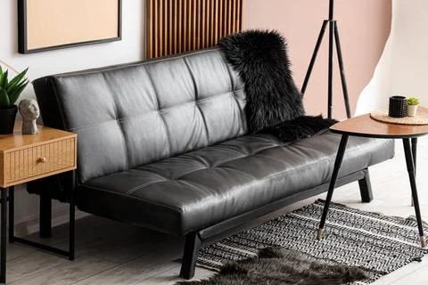 Modern black leather sofa with side table and decor Stock Photos