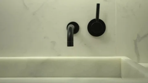 Modern black wall mounted basin mixer tap on light marble wall Vídeo Stock 80007301