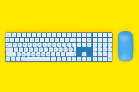 Modern blue aluminum computer keyboard and mouse isolated on yellow backgroun Stock Illustration