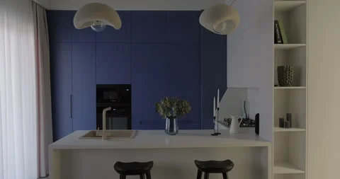 Modern blue kitchen interior design with build-in cabinet stone island sink Stock Footage 276136124
