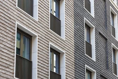 Modern brick facade with textured cladding and windows Stock Photos