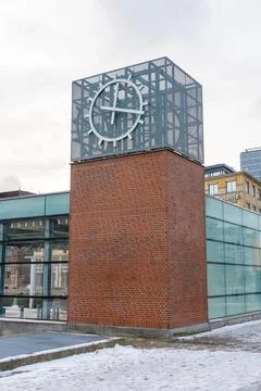Modern brick tower with large clock face and glass facade on a winter day. .. Stock Photos