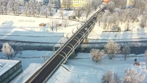 Modern bridge over Gauja river in Valmiera, winter transportation with snowfall Stock Footage 329004345