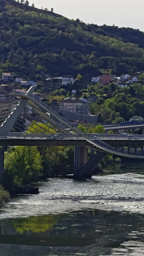 Modern Bridge over River with Hillside Houses Stock Footage 279060654