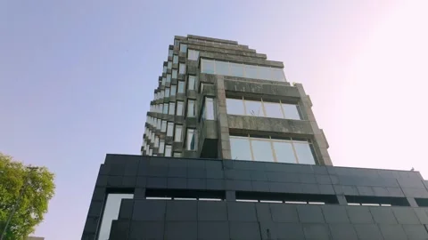 Modern brutalist architectural building with striking angular design against a Stock Footage 334612549