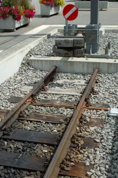 Modern buffer stop at the end of railway tracks on railway station. Stock Photos