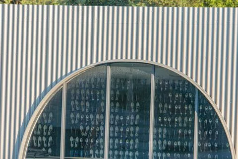 Modern building with an arched window filled with abstract designs, dark ex.. Fotos de archivo
