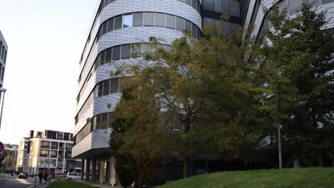 A modern building with a curved facade and unique design surrounded by greenery. Stock Footage 289218588