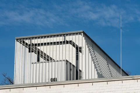 Modern building design with angular roof under blue sky Foto stock