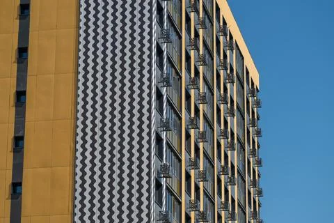 Modern building with distinct wall patterns in a city setting during daytime Stock Photos
