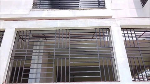 Modern building exterior featuring geometric metal security bars 库存影片 342169542