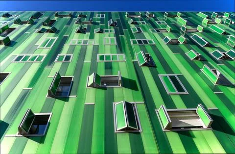 A modern building facade covered in vertical green corrugated panels featur.. Stock Photos