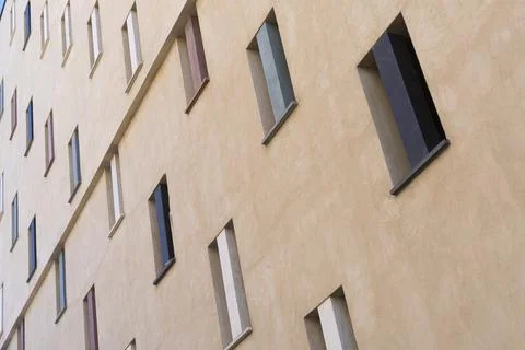 A modern building facade features a grid of rectangular windows Stock Photos