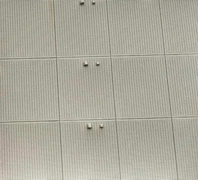 Modern building facade featuring a consistent grid pattern and visible ventil Фото