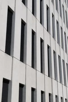Modern building facade featuring vertical narrow windows set Stock Photos